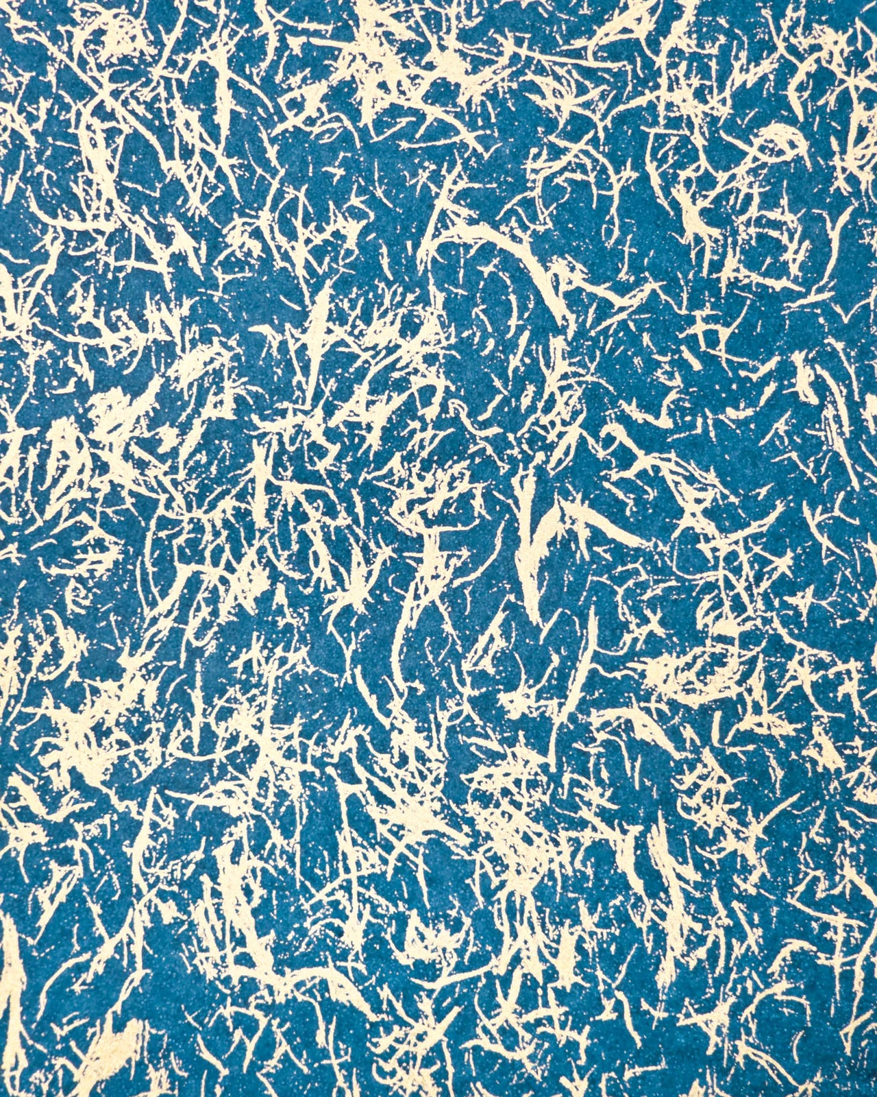 Japanese chiyogami paper featuring a metallic gold fiber-like unryu design on a blue background.