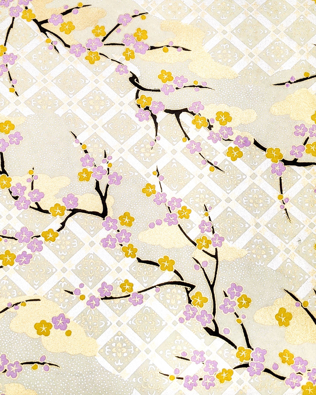 Japanese chiyogami paper featuring purple and orange plum blossoms with black branches set on top of a metallic silver hishi design on a cream background with metallic gold details.