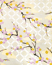 Japanese chiyogami paper featuring purple and orange plum blossoms with black branches set on top of a metallic silver hishi design on a cream background with metallic gold details.