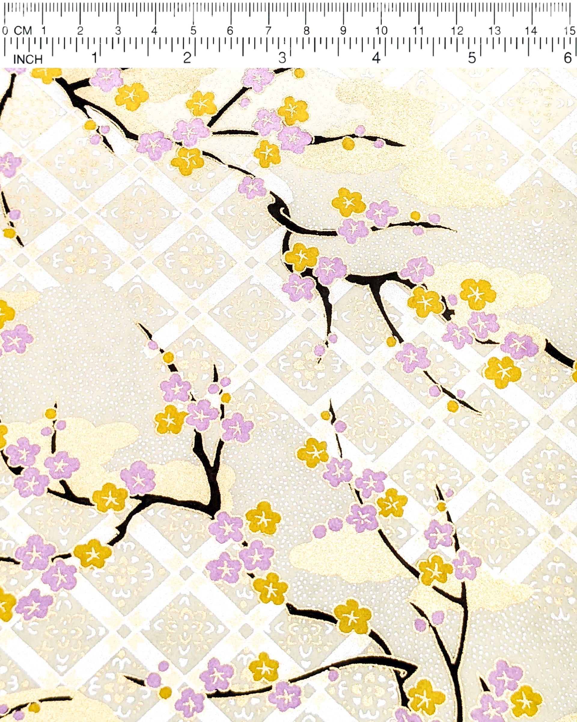 Japanese chiyogami paper featuring purple and orange plum blossoms with black branches set on top of a metallic silver hishi design on a cream background with metallic gold details.