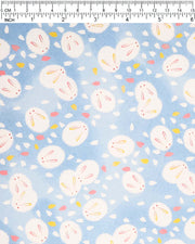 Japanese chiyogami paper featuring round white rabbits with pink and yellow ears surrounded by white, pink, and yellow flower petals on light blue background.
