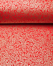 Japanese chiyogami paper featuring a metallic gold floral motif on a bright red background.