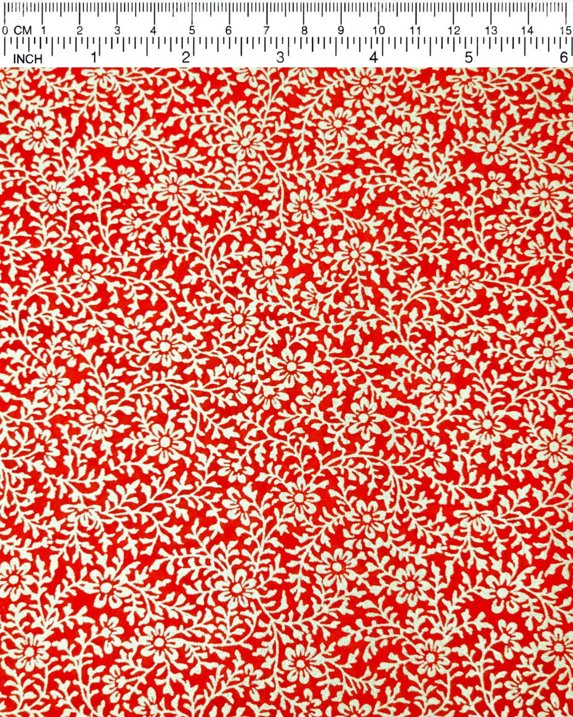 Japanese chiyogami paper featuring a metallic gold floral motif on a bright red background.