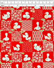 Japanese chiyogami paper featuring white snakes and white assorted traditional Japanese designs in an ichimatsu (checker) design on a red background with metallic gold details. Small pink flowers and green leaves accent the design.