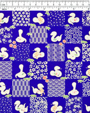 Japanese chiyogami paper featuring white snakes and white assorted traditional Japanese designs in an ichimatsu (checker) design on a blue background with metallic gold details. Small red flowers and green leaves accent the design.