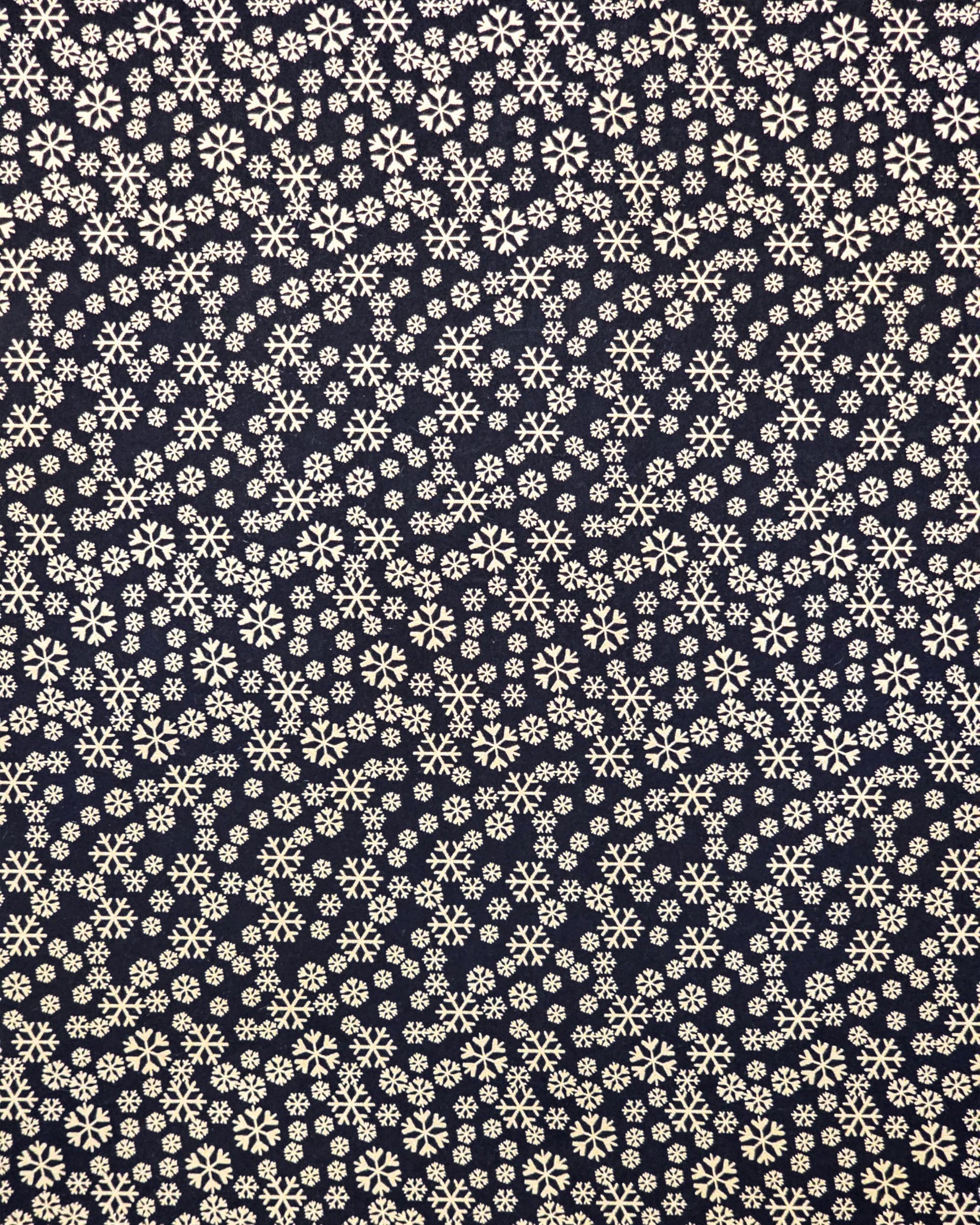 Japanese chiyogami paper featuring metallic gold snowflakes of various sizes on a black background.