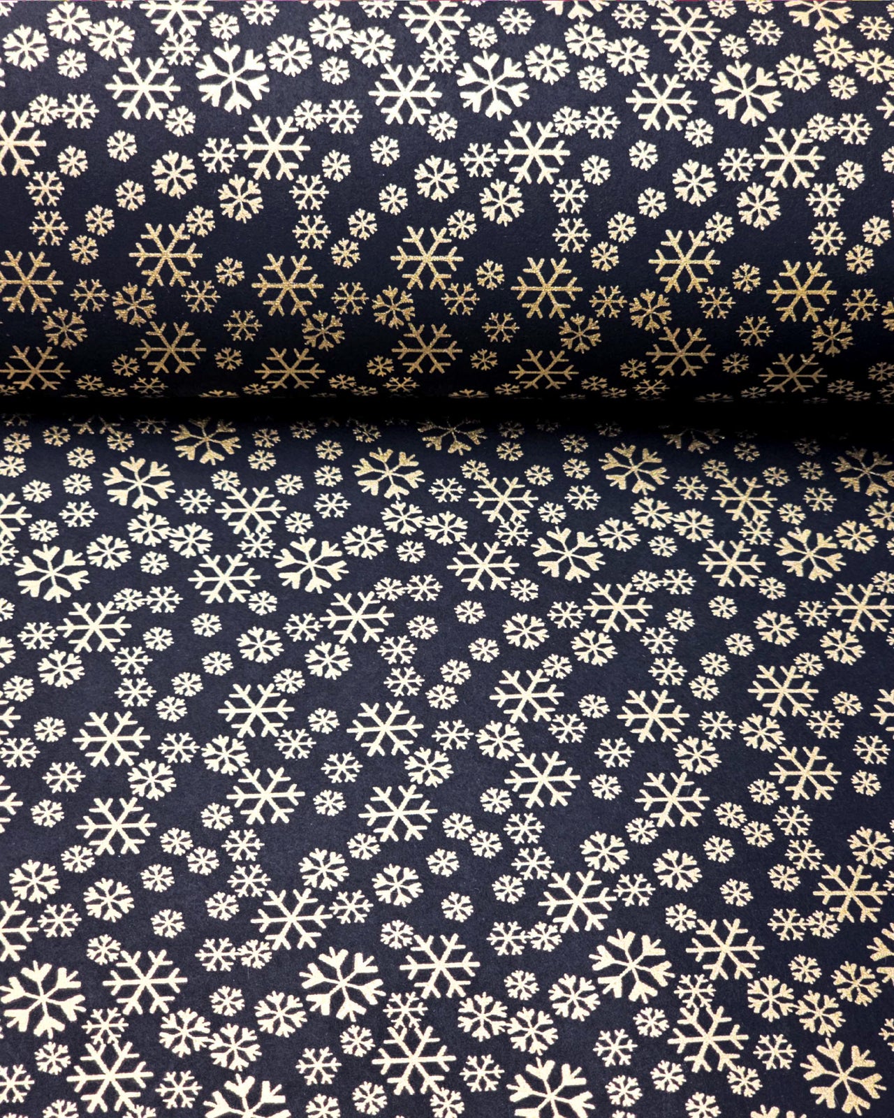 Japanese chiyogami paper featuring metallic gold snowflakes of various sizes on a black background.