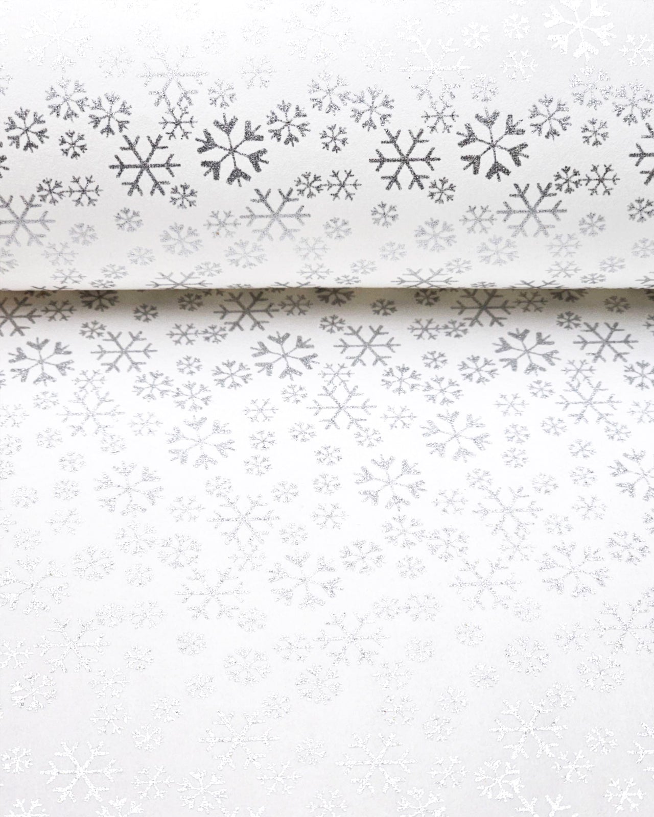 Japanese chiyogami paper featuring metallic silver snowflakes of various sizes on a white background.