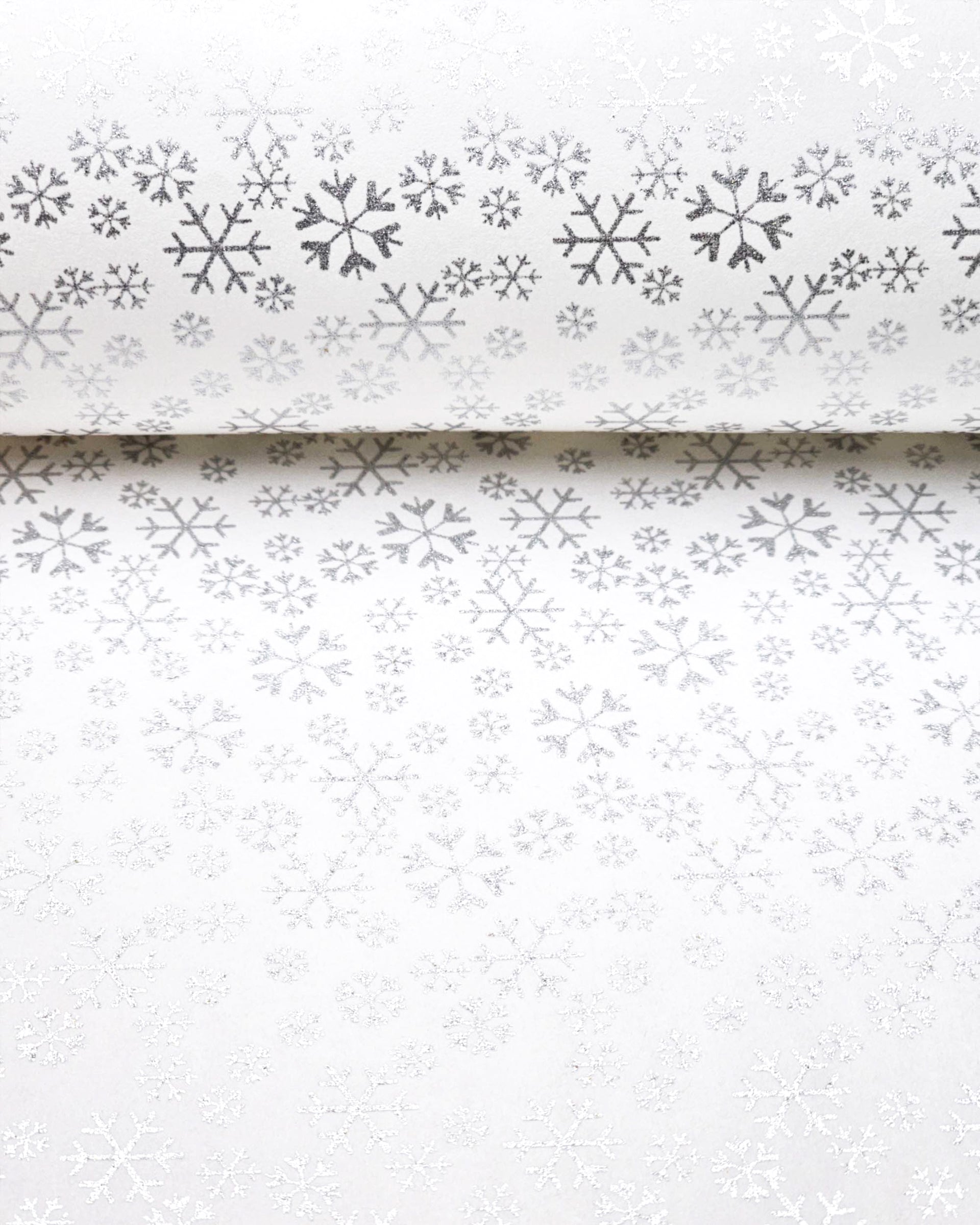 Japanese chiyogami paper featuring metallic silver snowflakes of various sizes on a white background.