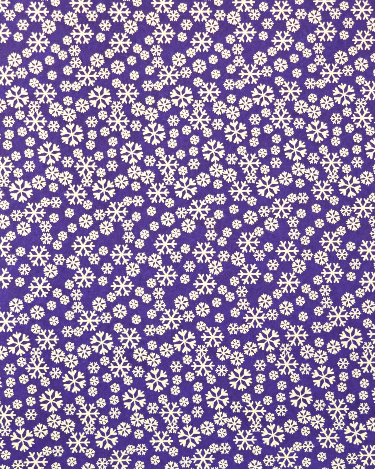 Japanese chiyogami paper featuring metallic gold snowflakes of various sizes on a dark blue background.