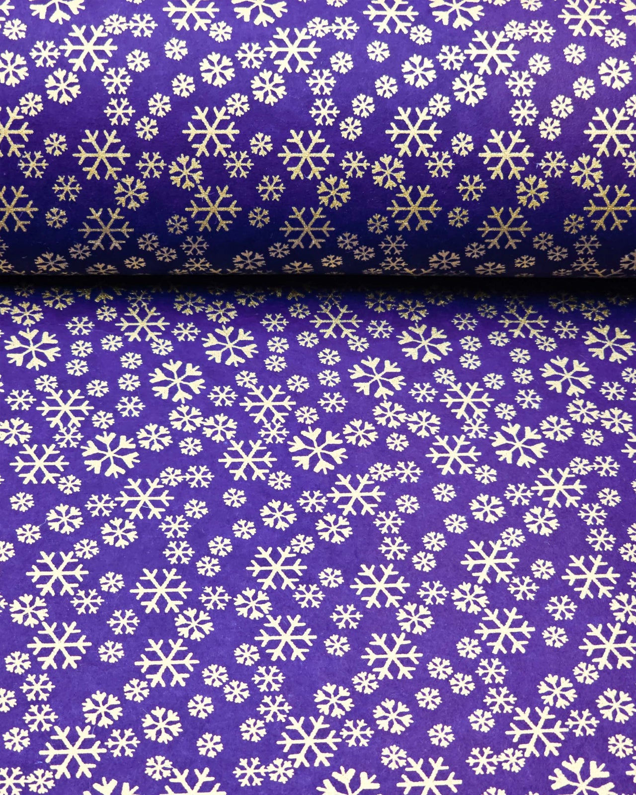 Japanese chiyogami paper featuring metallic gold snowflakes of various sizes on a dark blue background.