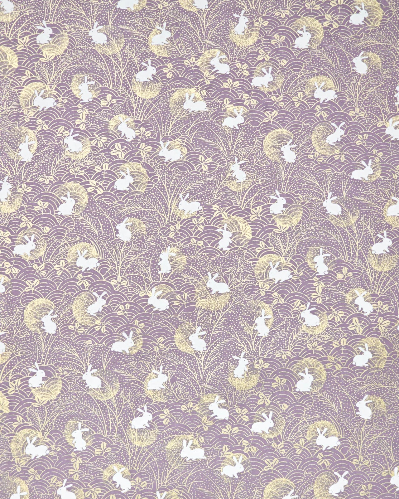 Japanese chiyogami paper featuring white rabbits with gold moons on a purple background with metallic gold details.