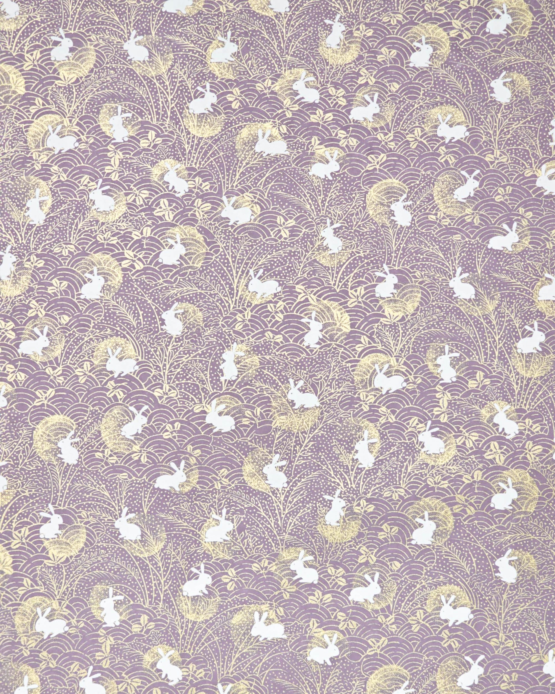 Japanese chiyogami paper featuring white rabbits with gold moons on a purple background with metallic gold details.
