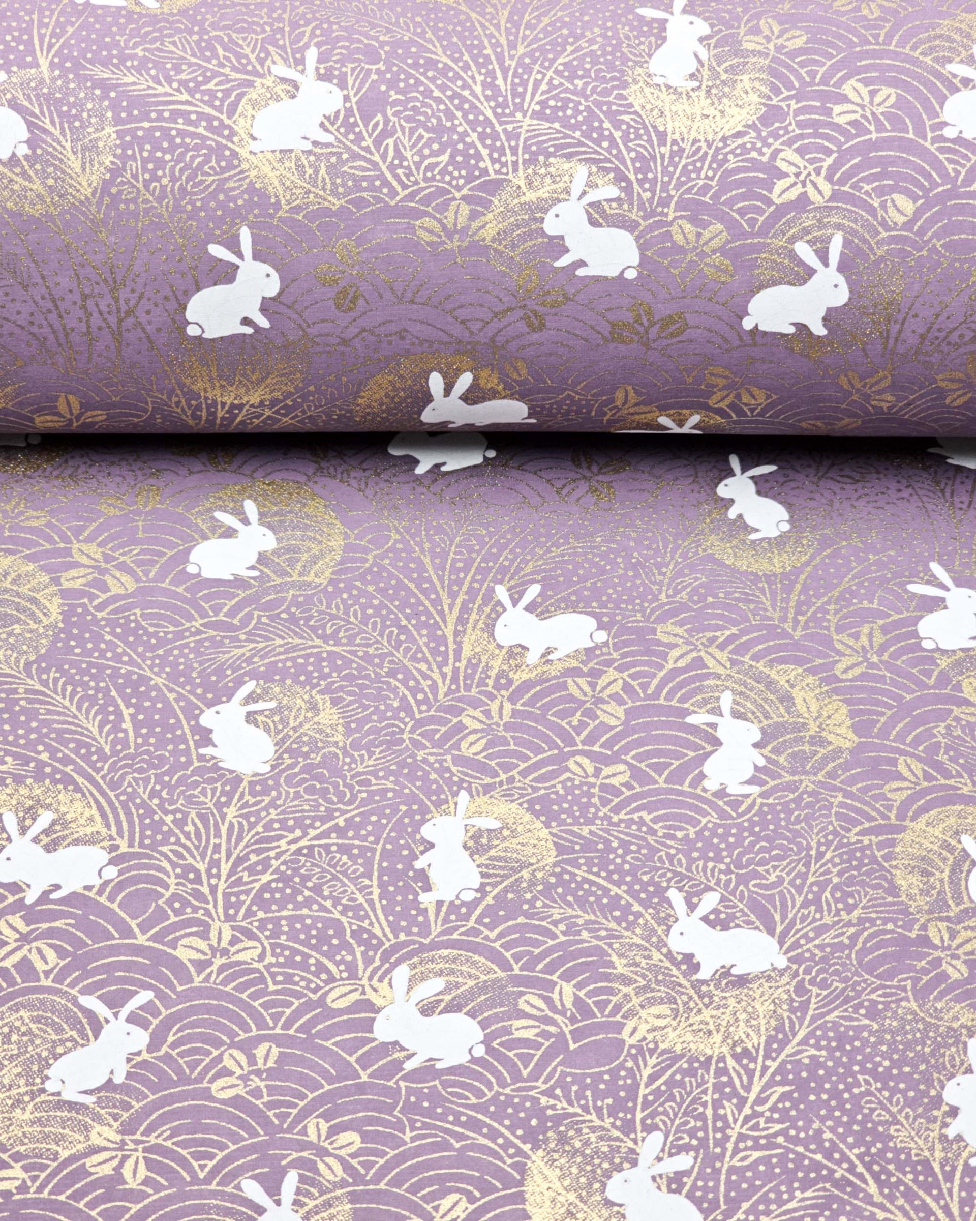 Japanese chiyogami paper featuring white rabbits with gold moons on a purple background with metallic gold details.