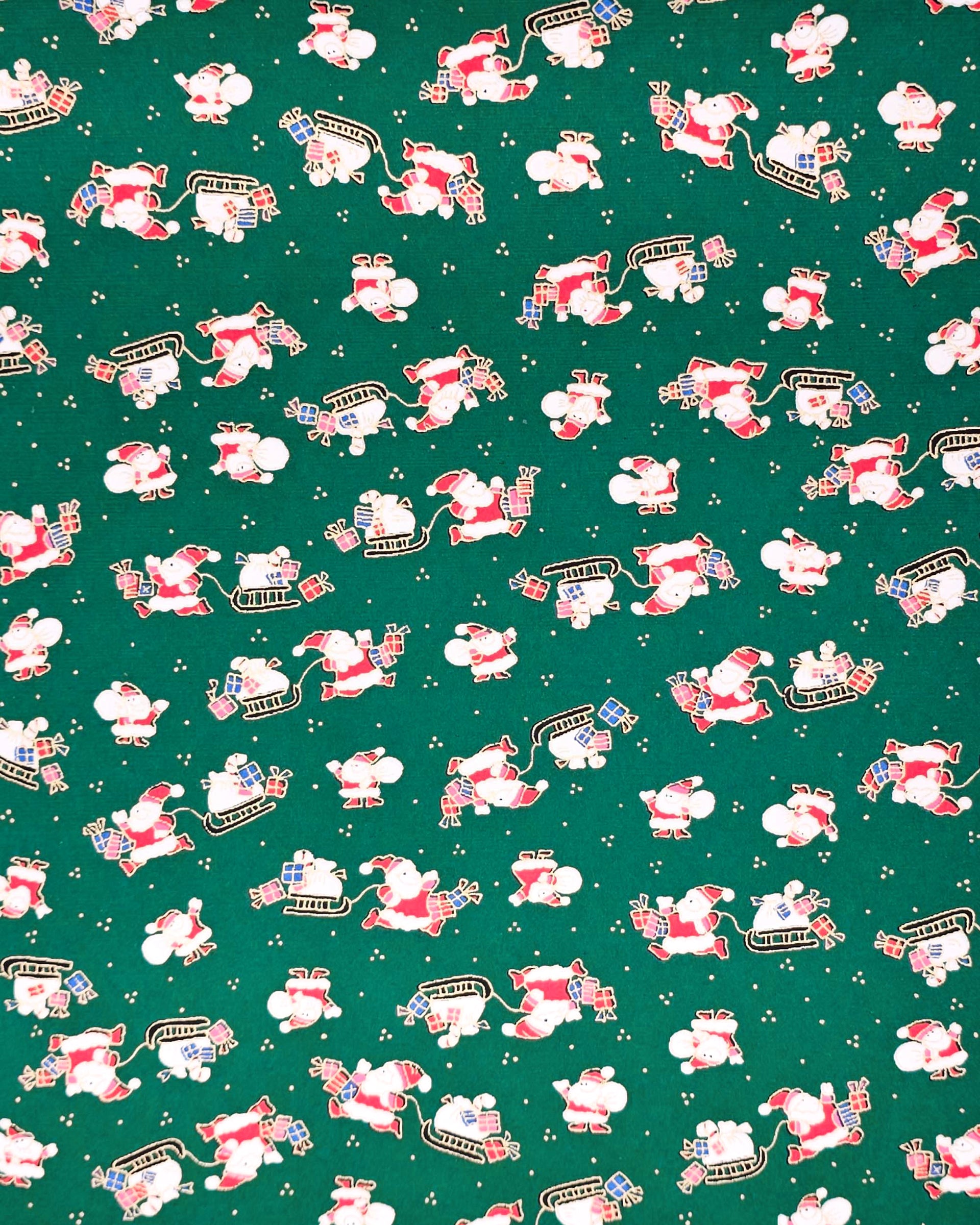 Japanese chiyogami paper featuring cartoon Santas in red outfits pulling sleds with presents and carrying sacks of presents on a green background with metallic gold details. 