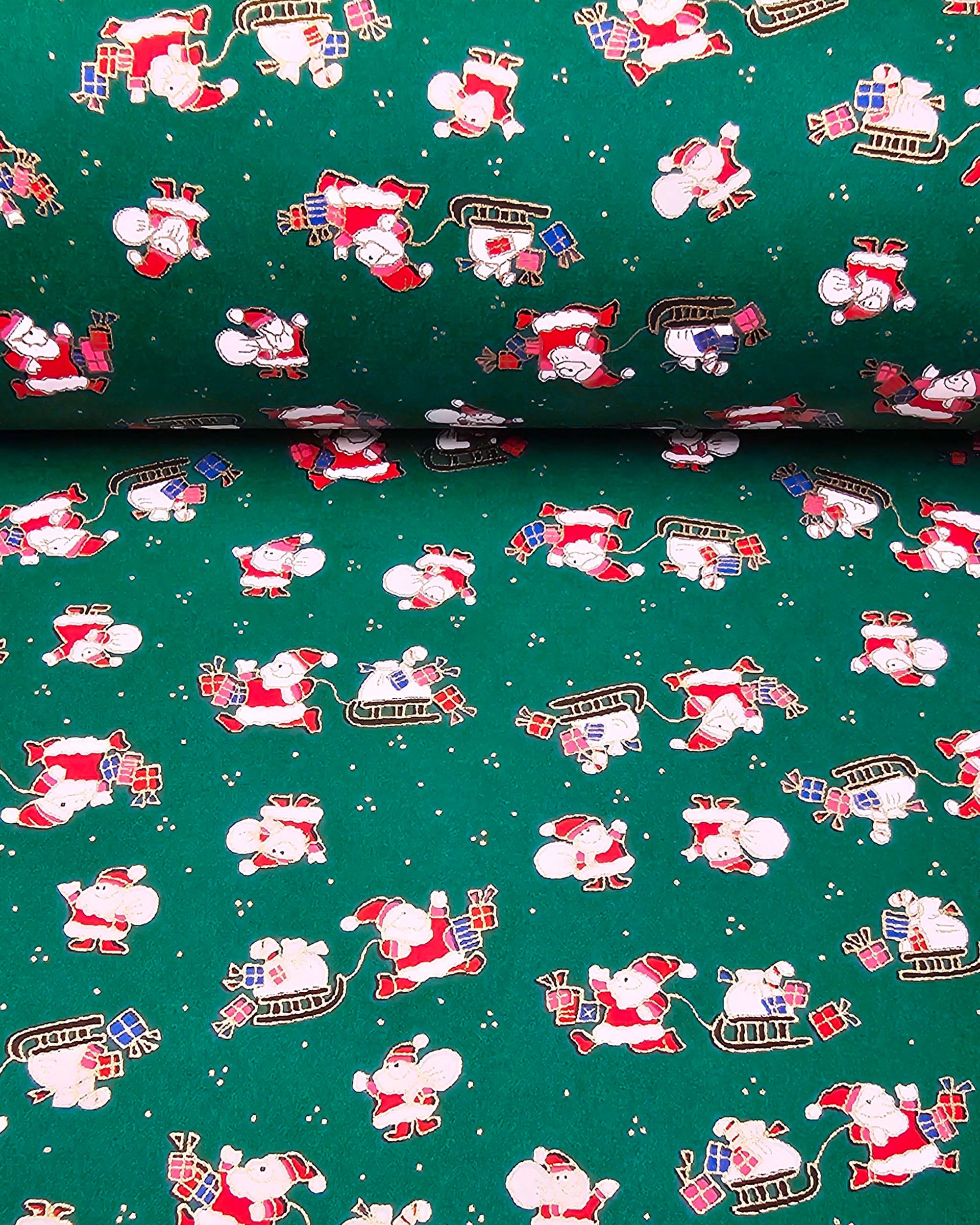 Japanese chiyogami paper featuring cartoon Santas in red outfits pulling sleds with presents and carrying sacks of presents on a green background with metallic gold details. 