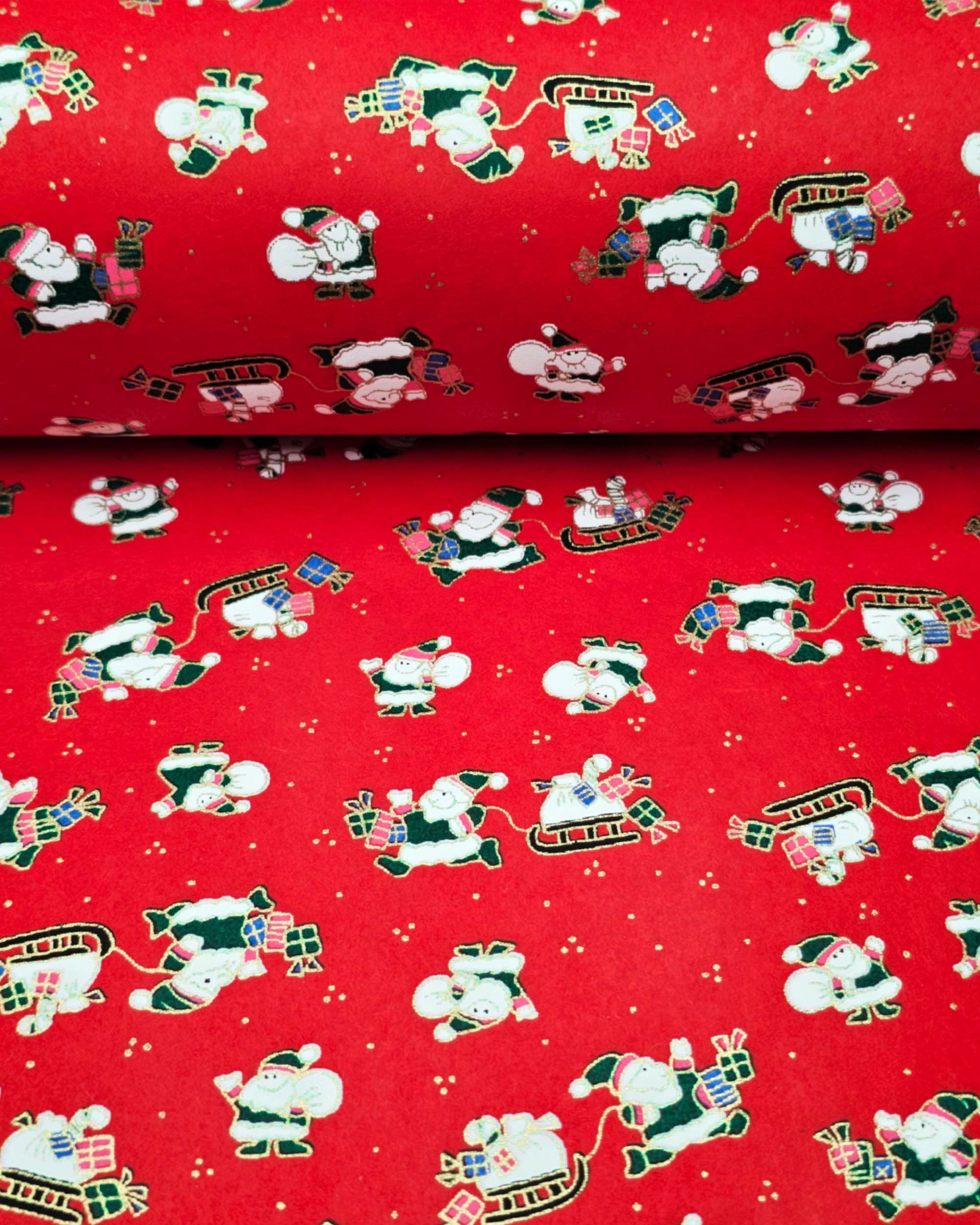 Japanese chiyogami paper featuring cartoon Santas in green outfits pulling sleds with presents and carrying sacks of presents on a red background with metallic gold details. 