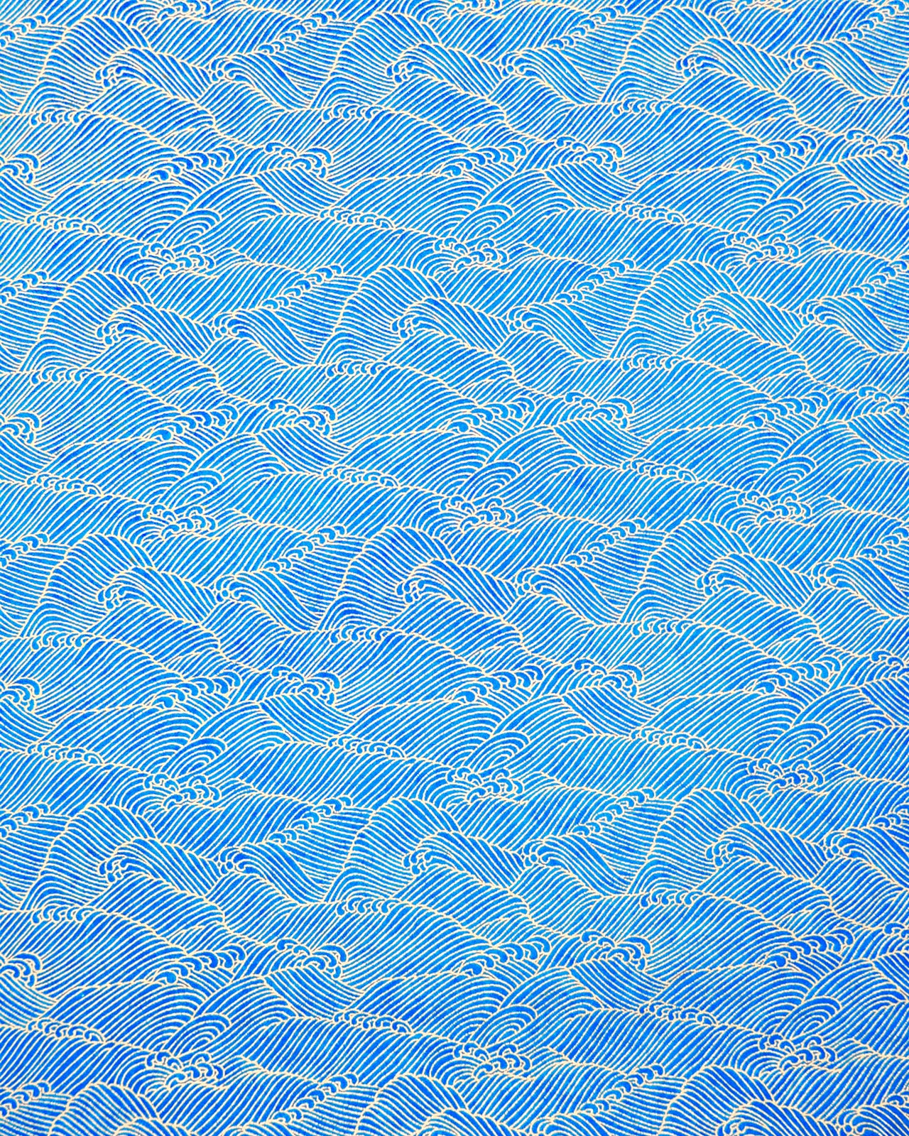 Japanese chiyogami paper featuring small metallic gold waves (aranami) on a royal blue background.