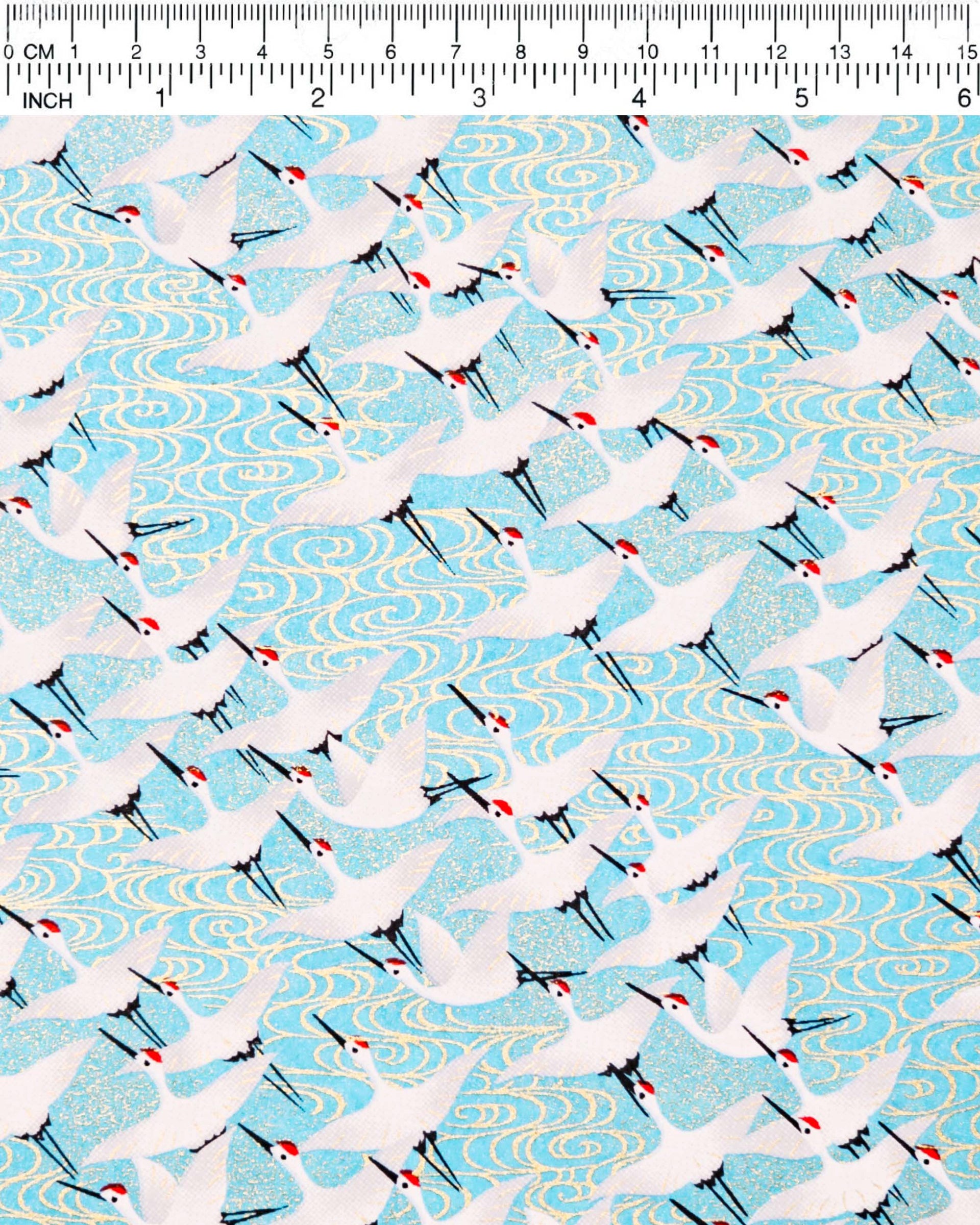 Japanese chiyogami paper featuring white flying cranes and gold kanzemizu (swirling water) on an aqua blue background with metallic gold details.