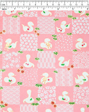 Japanese chiyogami paper featuring white snakes and white assorted traditional Japanese designs in an ichimatsu (checker) design on a pink background with metallic gold details.