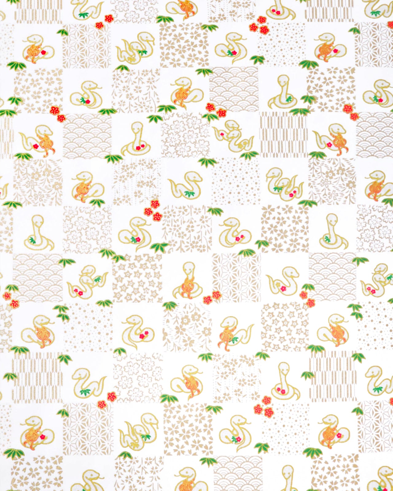 Japanese chiyogami paper featuring silver snakes and gold assorted traditional Japanese designs in an ichimatsu (checker) design on a white background with metallic gold details. Small red plum blossoms and green bamboo leaves are scattered throughout the design.
