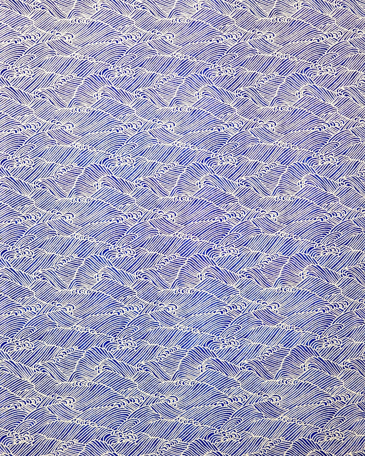 Japanese chiyogami paper featuring small metallic gold waves (aranami) on a dark blue background.