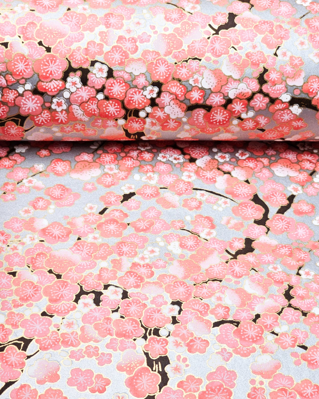 Japanese chiyogami paper featuring pink and white plum blossom trees with dark brown branches on a silver background with metallic gold details.