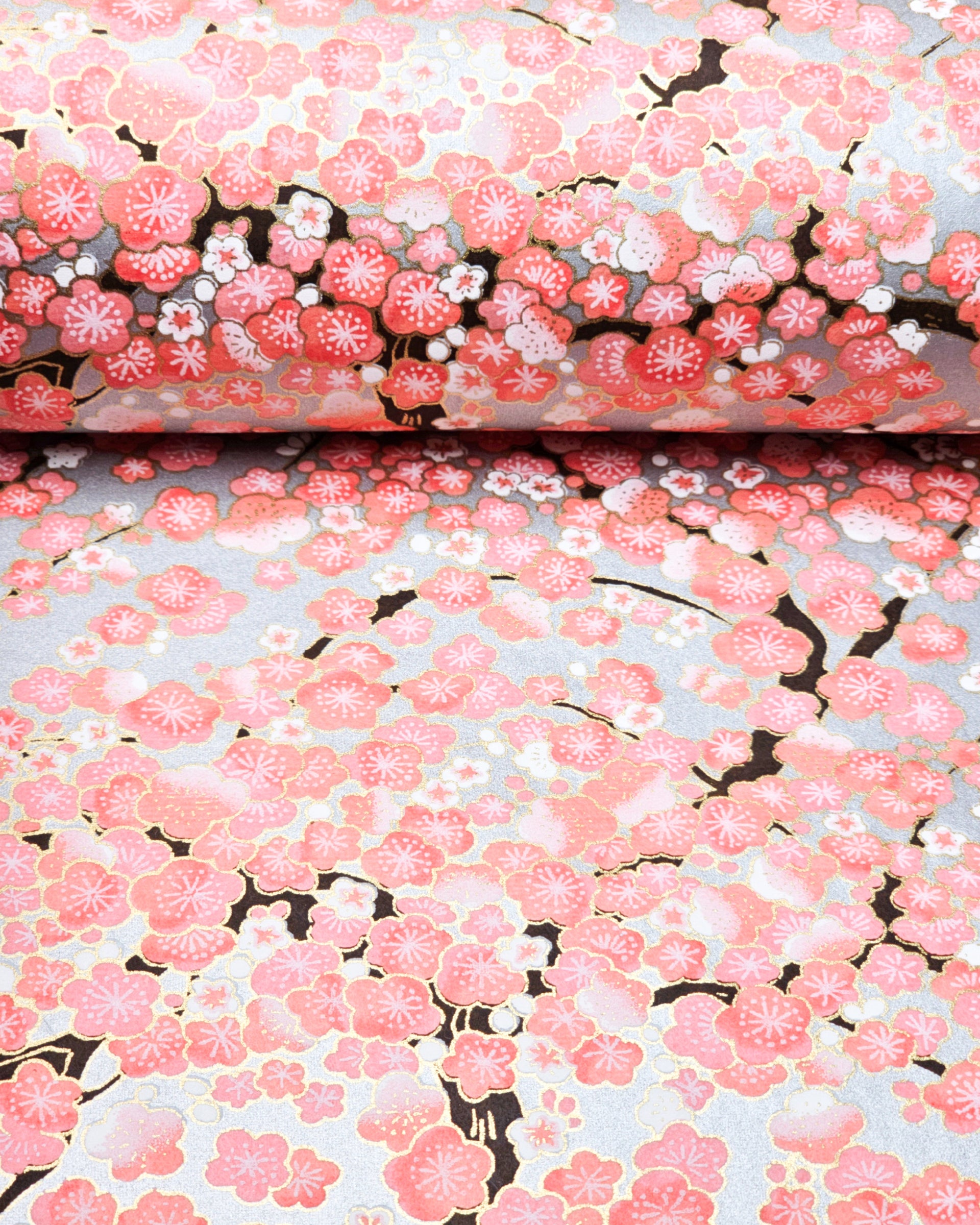 Japanese chiyogami paper featuring pink and white plum blossom trees with dark brown branches on a silver background with metallic gold details.