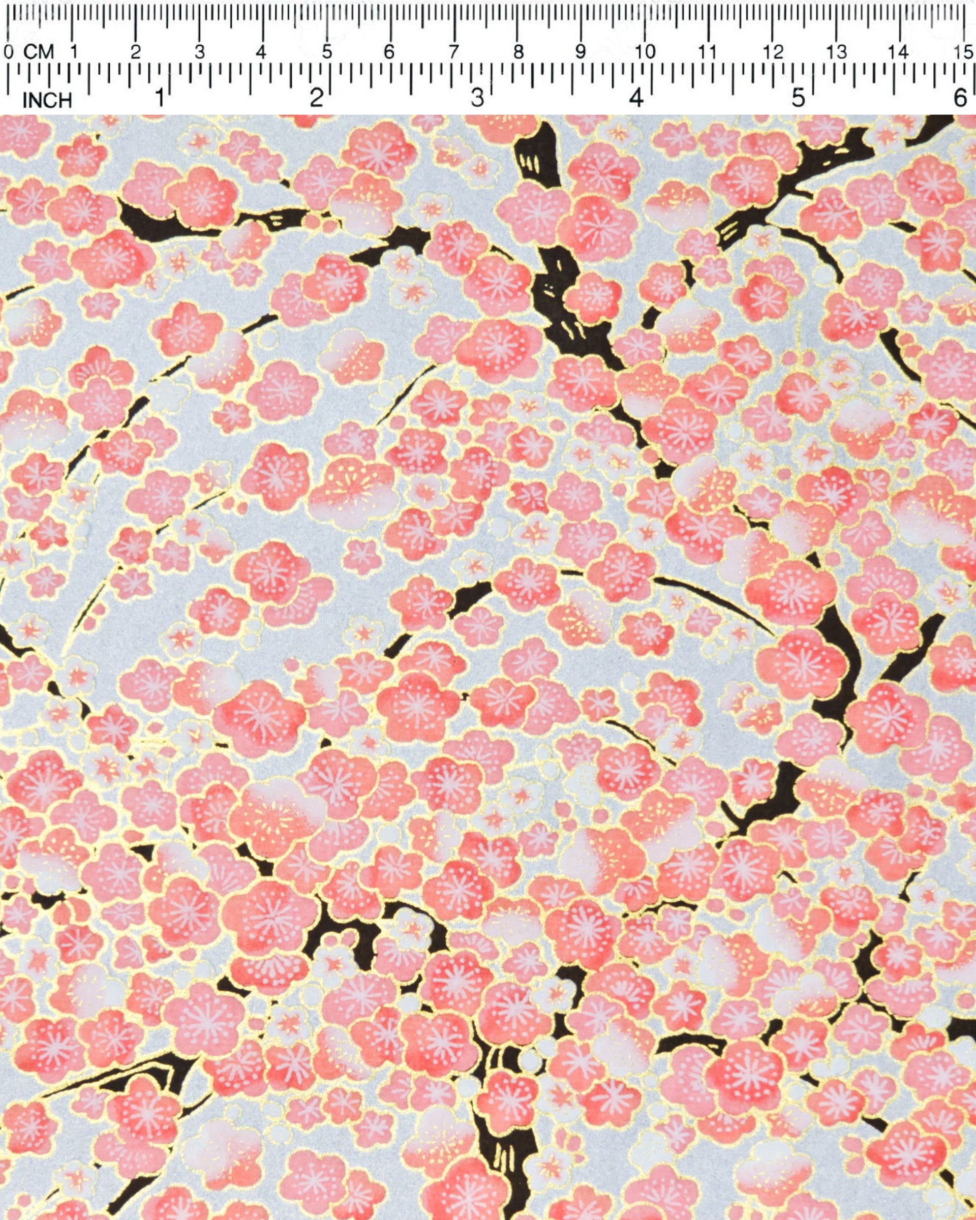 Japanese chiyogami paper featuring pink and white plum blossom trees with dark brown branches on a silver background with metallic gold details.