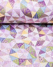 Japanese chiyogami paper featuring purple, yellow, green, and blue triangular patches decorated with assorted traditional Japanese motifs with metallic gold details.