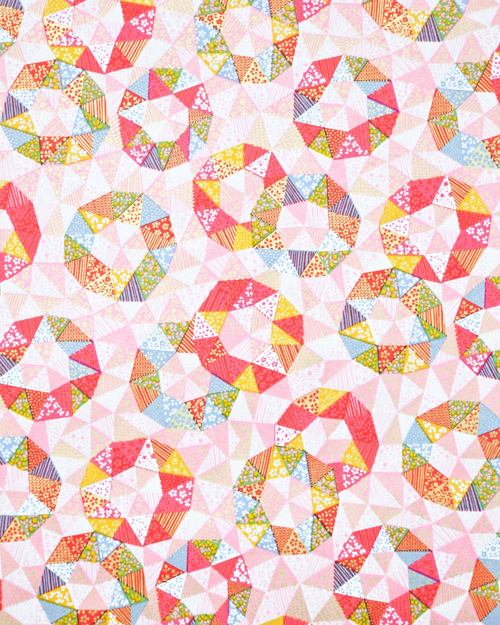 Japanese chiyogami paper featuring pink, yellow, green, and blue triangular patches decorated with assorted traditional Japanese motifs with metallic gold details.