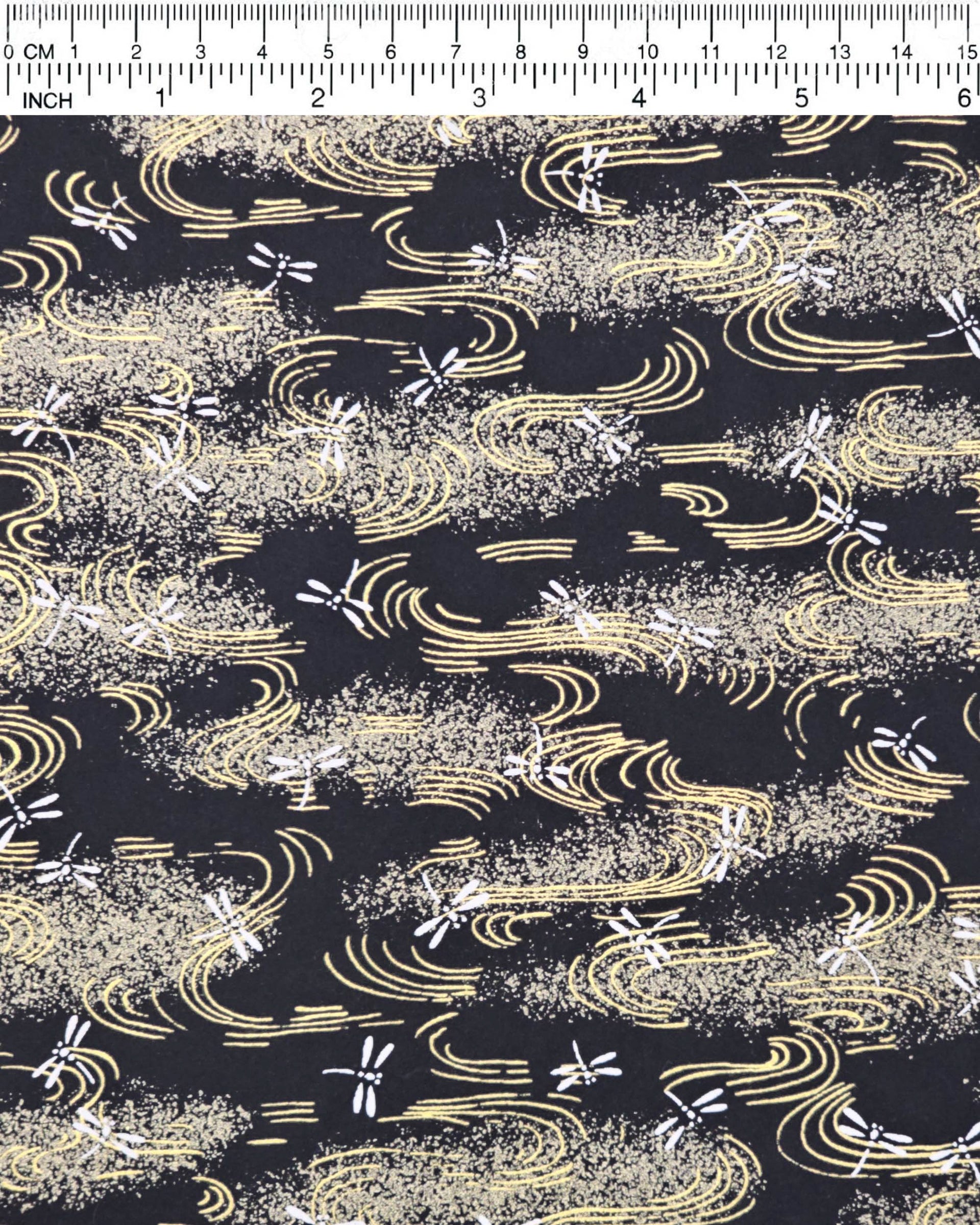Japanese chiyogami paper featuring white dragonflies on a black background with metallic gold wavy lines.