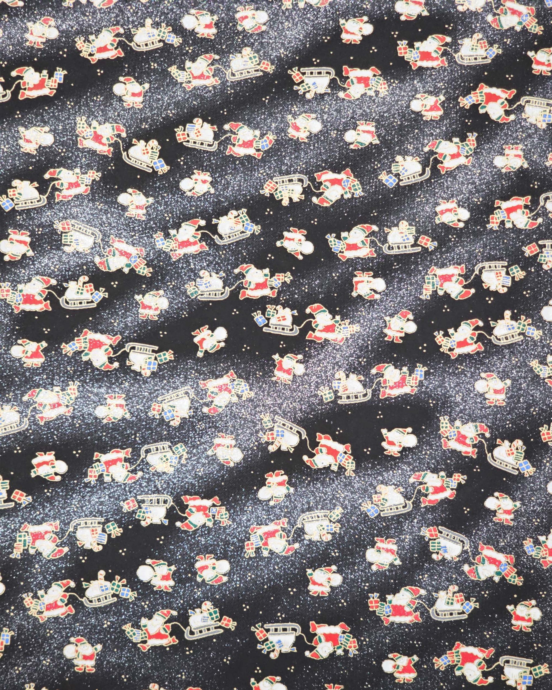 Japanese chiyogami paper featuring Santa and his sleigh on a black and background with metallic gold accents and metallic silver glitter.