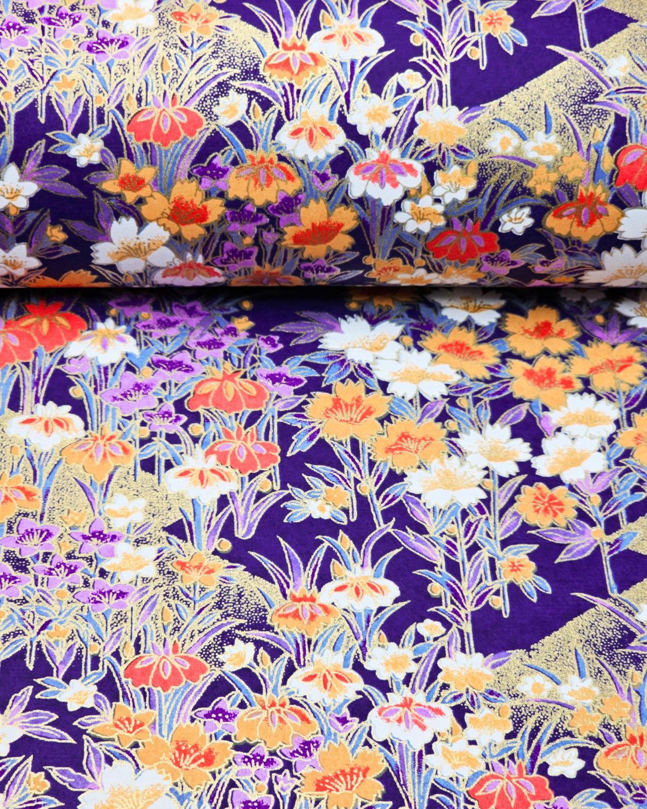 Japanese chiyogami paper featuring orange, purple, and white irises with green stems on a dark blue background with metallic gold details.