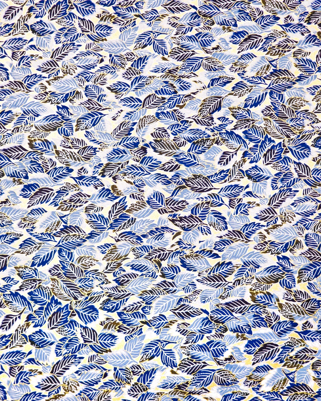 Japanese chiyogami paper featuring blue, black, and white leaves on a metallic gold background.