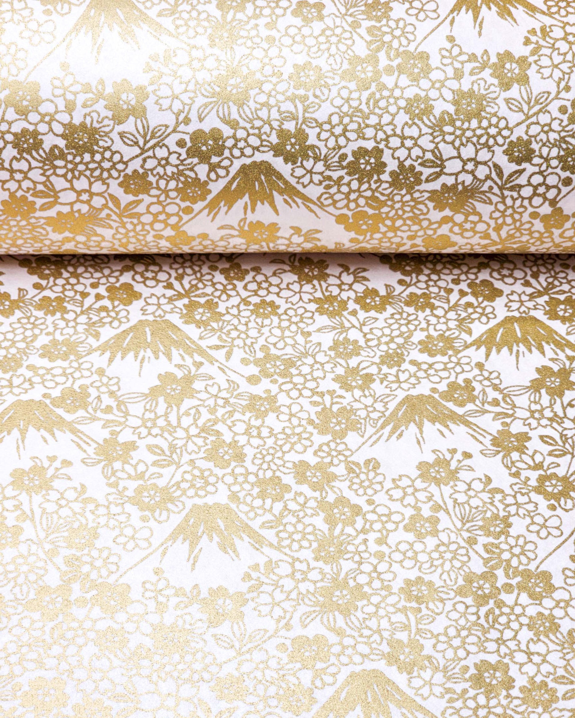 Japanese chiyogami paper featuring metallic gold Mt. Fujis and cherry blossoms on a light pink background.