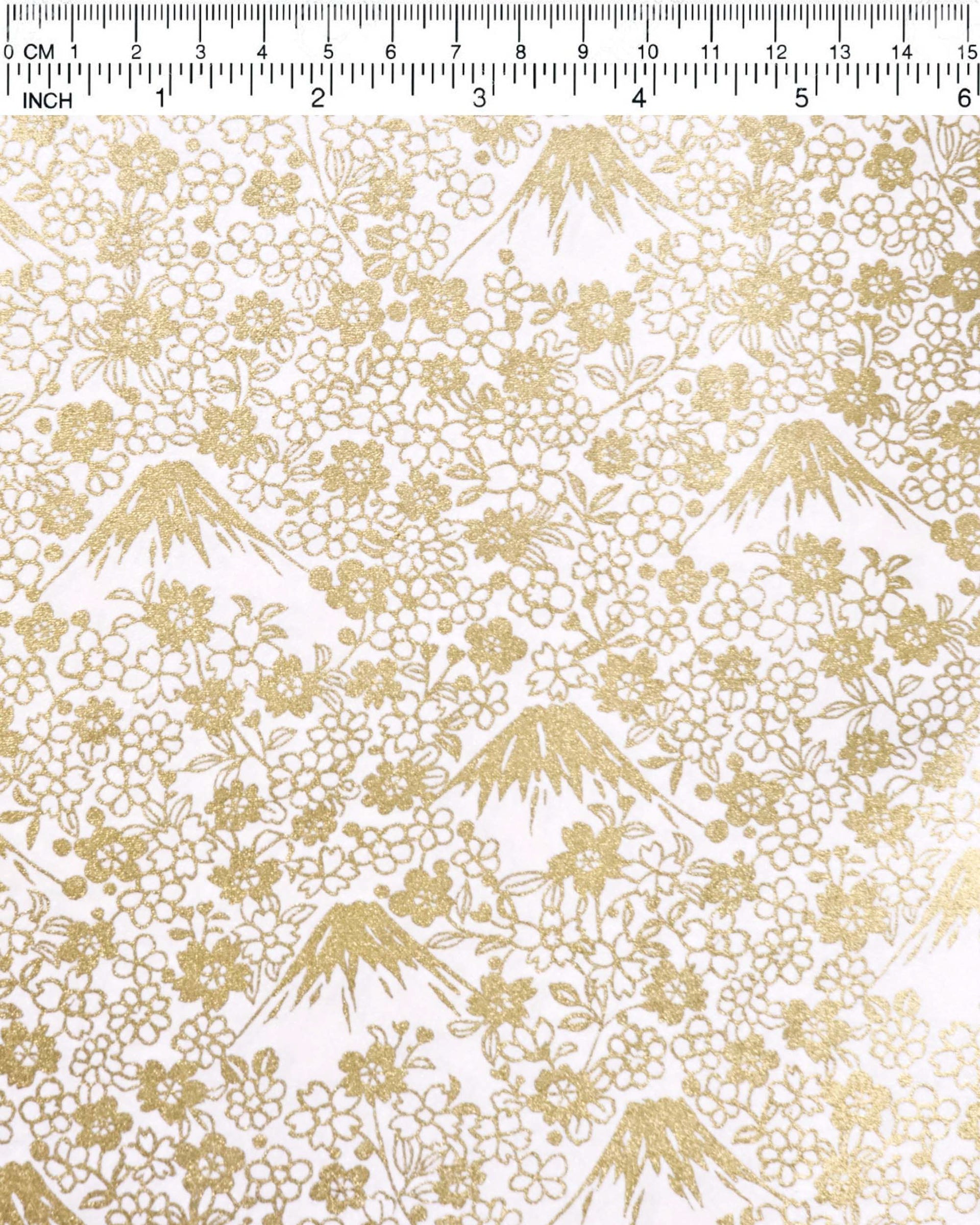 Japanese chiyogami paper featuring metallic gold Mt. Fujis and cherry blossoms on a light pink background.