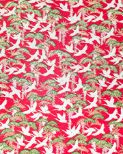 Japanese chiyogami paper featuring white flying cranes, purple and white wisteria, and green pine on a pearlescent red background with metallic gold details.