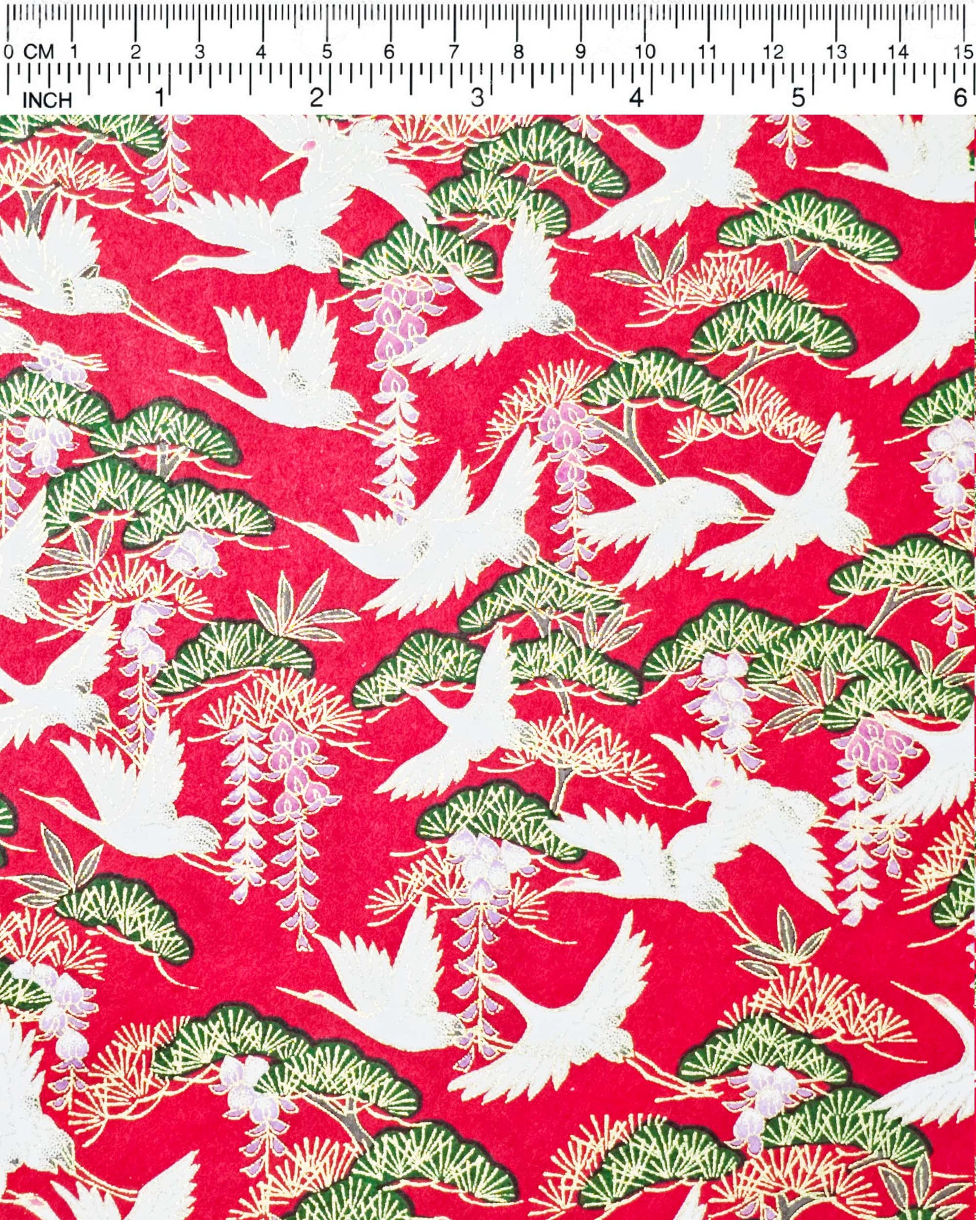 Japanese chiyogami paper featuring white flying cranes, purple and white wisteria, and green pine on a pearlescent red background with metallic gold details.