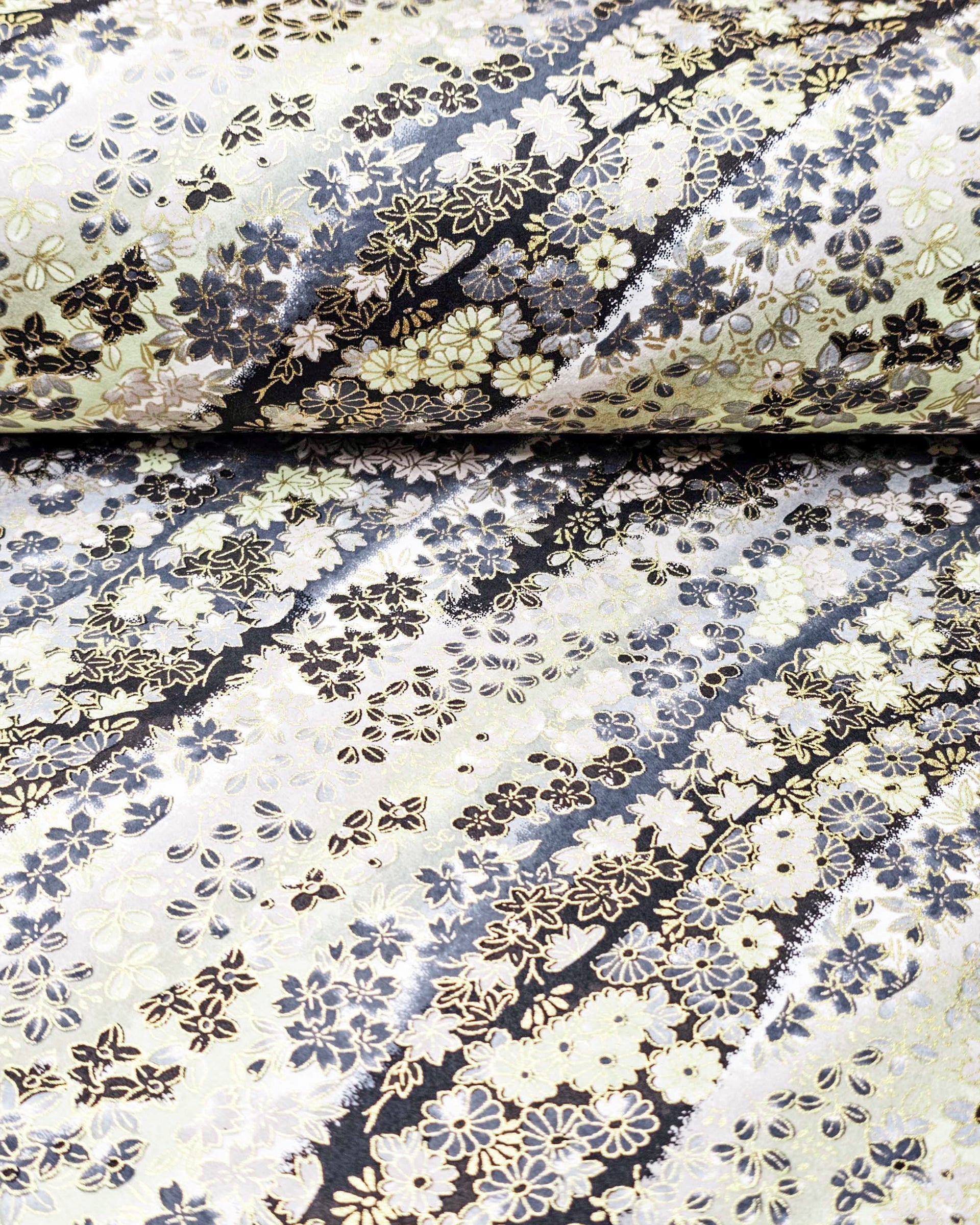 Japanese chiyogami paper featuring assorted gray and cream flowers on a gray and black background with metallic gold accents.