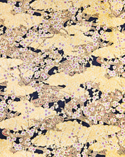 Japanese chiyogami paper featuring small white plum blossom branches with red and gold water ripples and large gold clouds on a black background with metallic gold details. 
