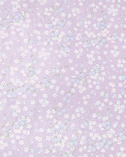 Japanese chiyogami paper featuring light blue and white cherry blossoms with green leaves and branches on a pearlescent light purple background.