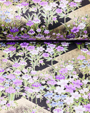 Japanese chiyogami paper featuring blue, purple, and white irises on a black background with metallic gold accents.