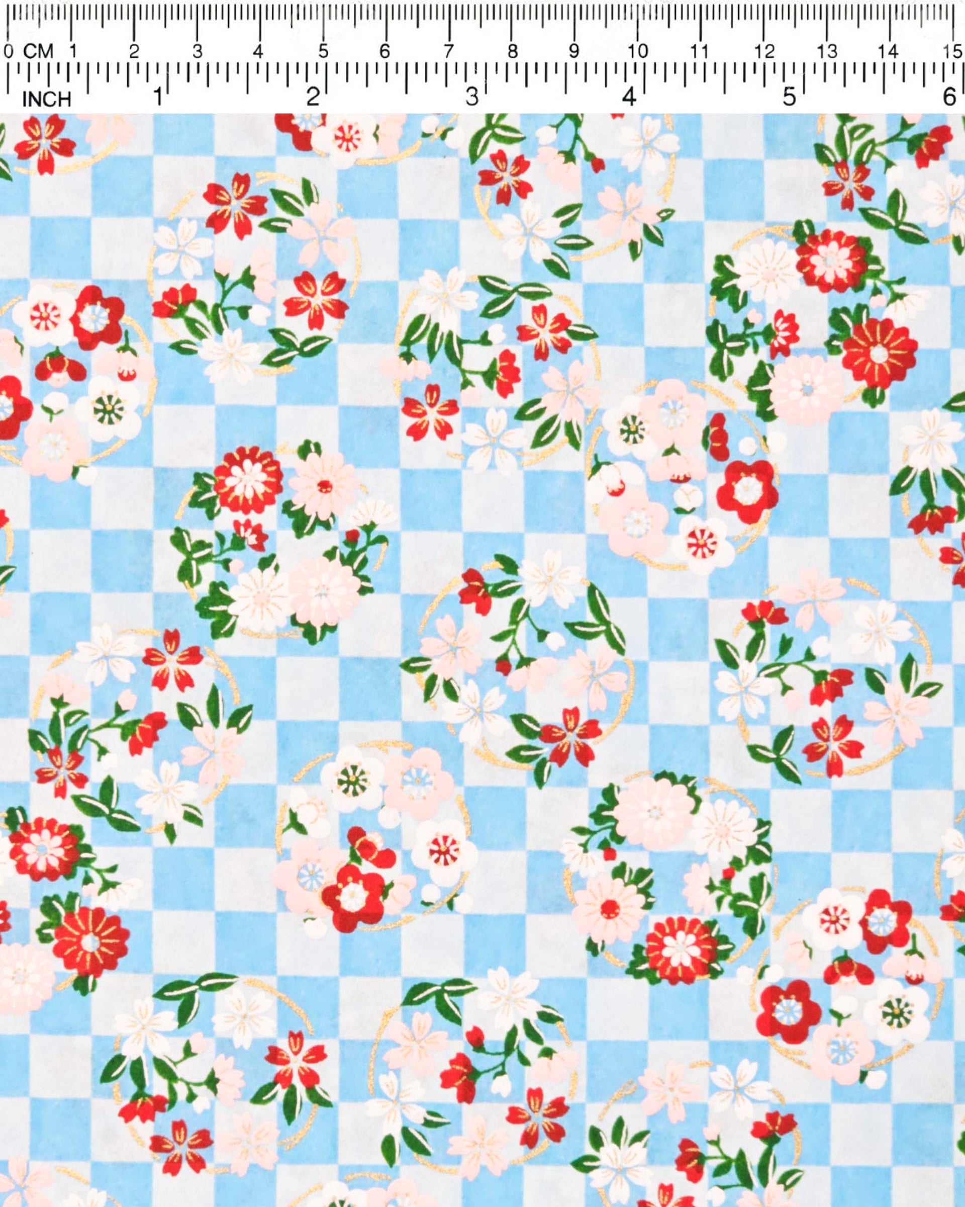 Japanese chiyogami paper featuring light pink, red, and white flowers with green leaves on a light blue ichimatsu (checkered) background with metallic gold accents.