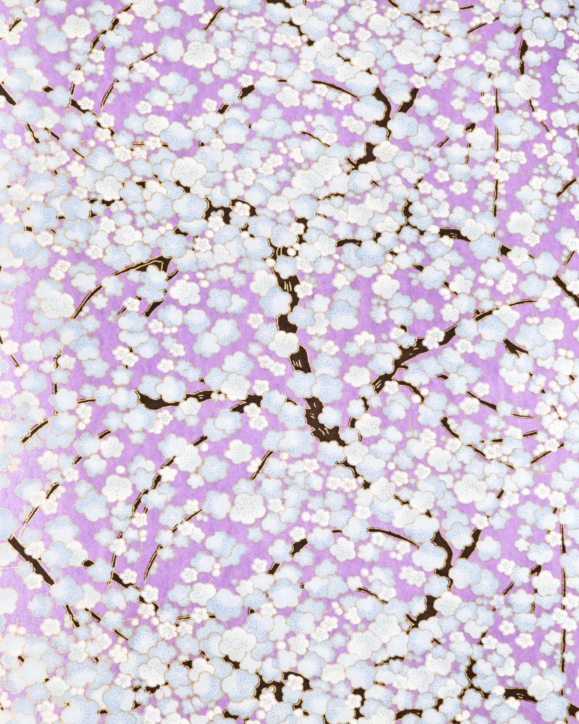 Japanese chiyogami paper featuring light blue plum blossom trees with dark brown branches on a pearlescent light purple background with metallic gold details.