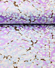 Japanese chiyogami paper featuring light blue plum blossom trees with dark brown branches on a pearlescent light purple background with metallic gold details.