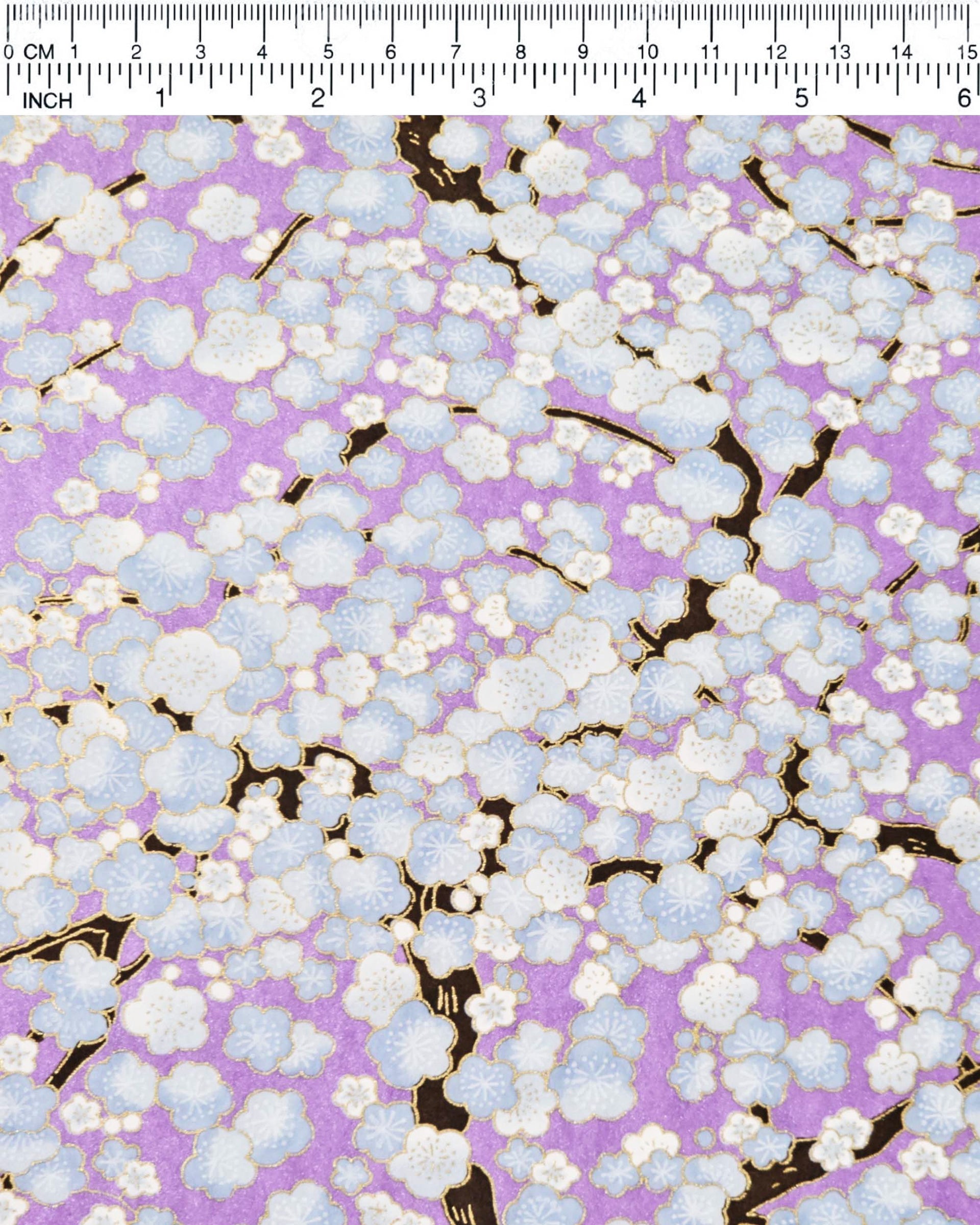 Japanese chiyogami paper featuring light blue plum blossom trees with dark brown branches on a pearlescent light purple background with metallic gold details.