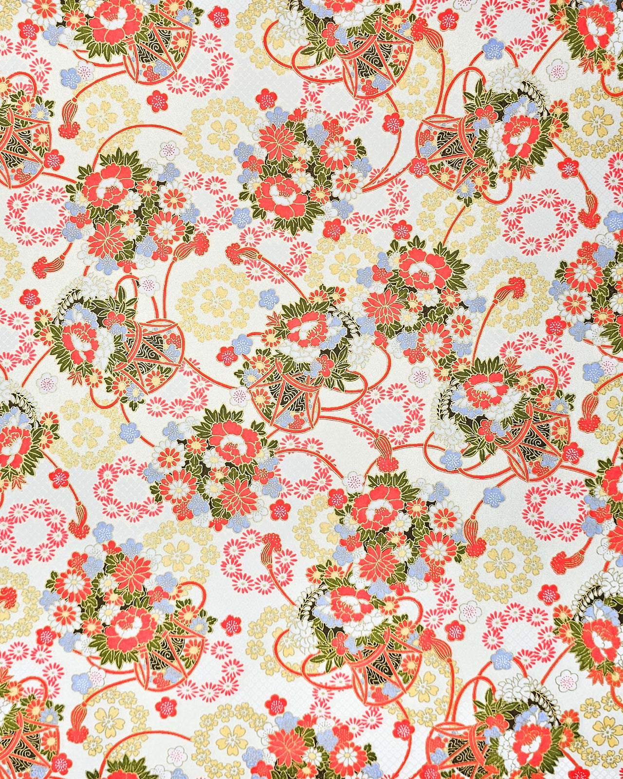 Japanese chiyogami paper featuring assorted red, light blue, and white flowers with green leaves inside red drums on a pearlescent white background with metallic gold accents. 