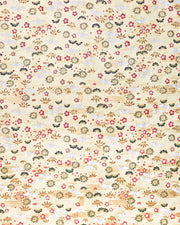 Japanese chiyogami paper featuring small white folded origami cranes with green pine and red plum blossoms on a metallic gold background.