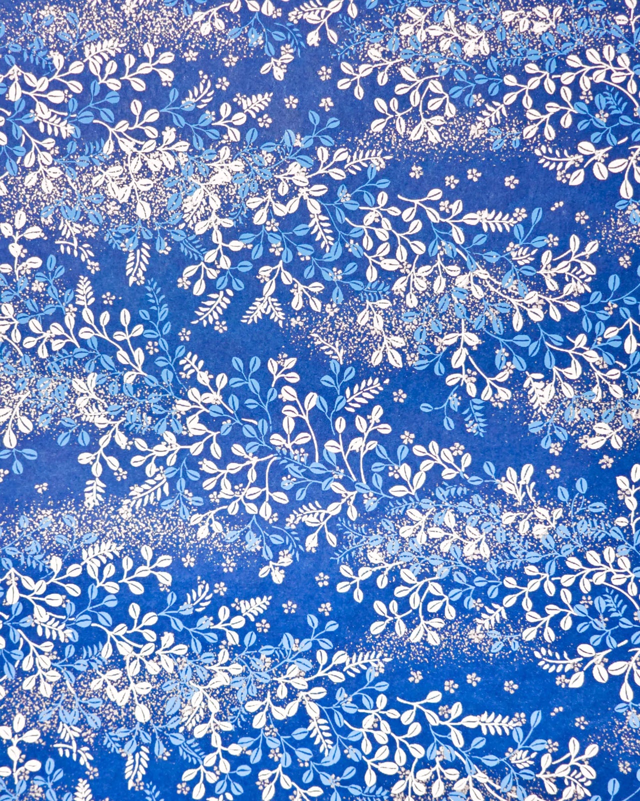 Japanese chiyogami paper featuring blue and white hagi (bush clover) on a blue background with metallic gold details. 